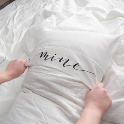 Putting on a king size pillow cover with the lettering 'mine'